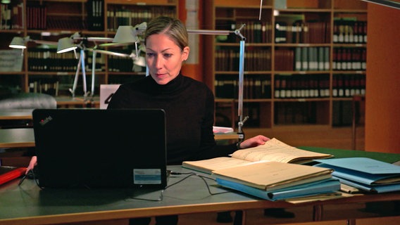 Provenienzforscherin und "Kunst-Detektivin" Dr. Kathrin Kleibl bei Recherchen am Laptop und in alten Unterlagen. © NDR 