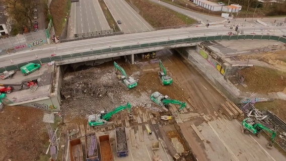 Dieses Mal wird das noch verbliebene Brückenelement an der Ausfahrt Othmarschen abgebrochen. Dazu wird eine neue gigantische Brücke für Verkehrsschilder raus- und eingehoben. © NDR/Auftragsproduktion/Adamfilm 