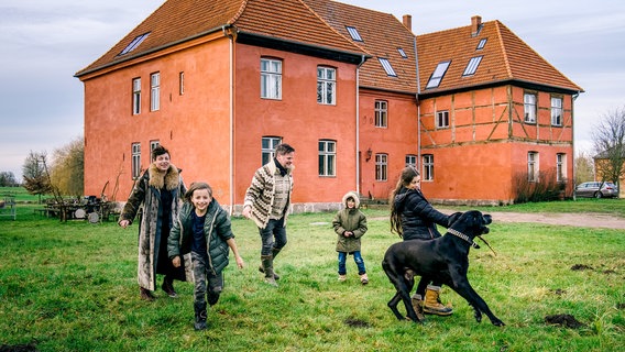 Immer in Bewegung: Christina von Ahlefeld und Knut Splett-Henning vor ihrem Haus in Rensow mit den Kindern Wilhelmine, Bendix und Balthasar. Familienhund Triglaf ist eine dänische Dogge. © NDR/Populärfilm 