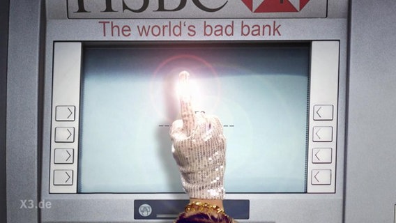 Eine Hand mit Glitzerhandschuh vor einem Geldautomaten zeigt den Mittelfinger.  