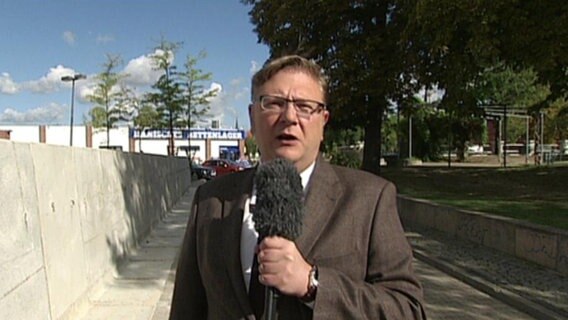 Ein Journalist vor der Mauer in Staßfurt Sachsen-Anhalt.  