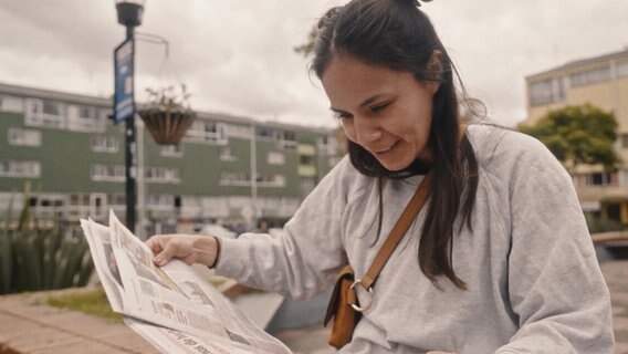 Elisa schaut in eine Zeitung. Sie sucht in Bogota nach ihrer leiblichen Mutter. © Drive Beta/Benjamin Kahlmeyer 