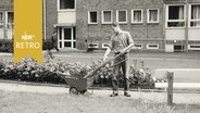 Ersatzdienst leistender junger Mann mit Straßenfegerausrüstung auf einem Gehsteig 1964  