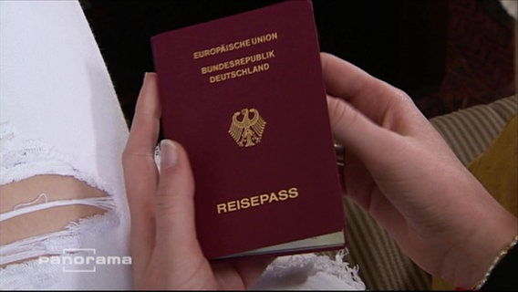 Eine junge Frau hält ihren deutschen Reisepass in den Händen  