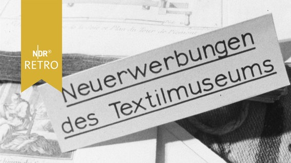 Schild "Neuerwerbungen des Textilmuseums" in einer Vitrine in Neumünster 1964  