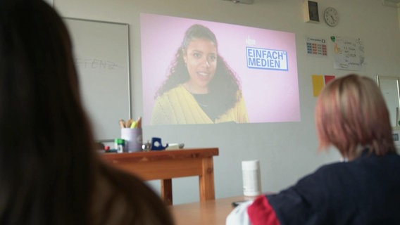 NDR Presenterin Lia Gavi erscheint auf einem Whiteboard vor Schülern. © NDR 
