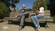 Ein Mann und eine Frau sitzen auf einer Parkbank und lesen jeweils ein Buch. © Screenshot 