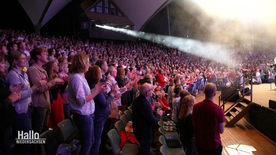 Blick in das Publikum, das am Ende einer Aufführung bei der Freilichtbühne Meppen Standing Ovations gibt. © Screenshot 