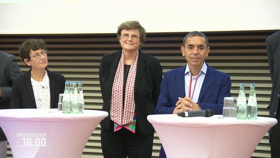 Das Biontech-Gründerduo Özlem Türici und Ugur Sahin neben anderen Personen auf einer Preisverleihung. © Screenshot 