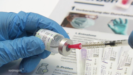 Eine Spritze wird zur Impfung aufgezogen. © Screenshot 