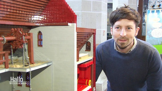 Torsten Poschmann neben einem aus Lego gebautem Gebäude © Screenshot 