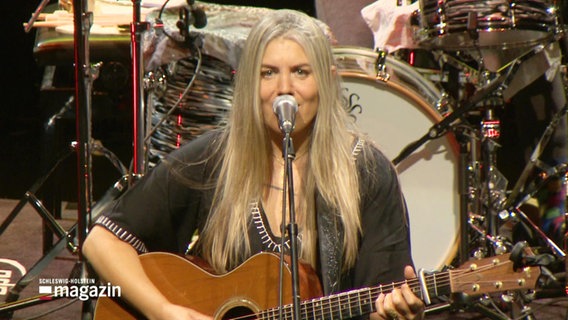Sängerin Yael Deckelbaum steht auf der Bühne, singt in ein Standmikro und begleitet sich selbst auf der Akustik-Gitarre. © Screenshot 