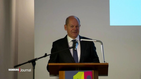 Bundeskanzler Olaf Scholz spricht auf einer Bühne von einem Rednerpult. © Screenshot 