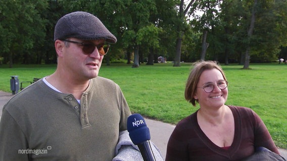 Ein Mann und eine Frau sprechen in ein Mikrofon. © Screenshot 