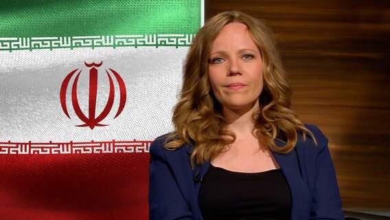 Sarah Bosetti vor der iranischen Flagge. © NDR 