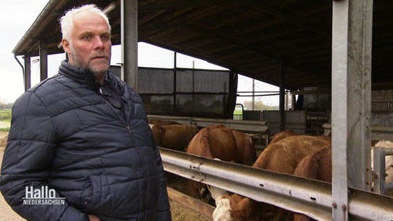 Landwirt Karsten Reinstorf steht vor einem offenen Unterstand mit Kühen. © Screenshot 