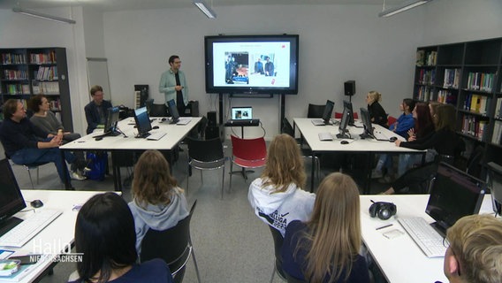 Ein Reporter zeigt Schülern eine Power-Point Präsentation. © Screenshot 