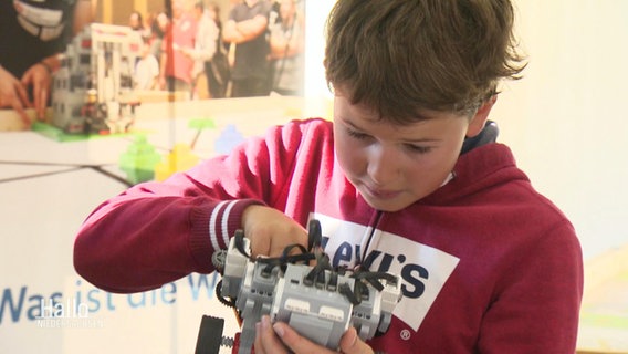 Ein Schüler werkelt an seinem Lego-Roboter. © Screenshot 
