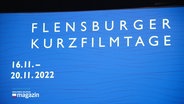 Auf einer Kinoleinwand steht: "Flensburger Kurzfilmtage". © Screenshot 