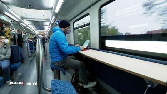 Eine Person sitzt an einem Arbeitsplatz in einer S-Bahn. © Screenshot 