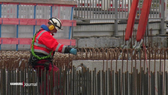Arbeitende an der A7 legen die Stahlstreben für die weitere Brückenarbeit mit einem Kran ab © Screenshot 