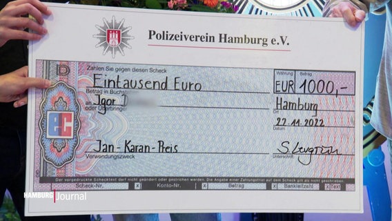 Ein symbolischer Scheck des Polizeivereins Hamburg über 1.000 €. © Screenshot 