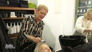 Frisörin Sabine Herrmann wäscht einer Kundin in ihrem Salon die Haare. © Screenshot 