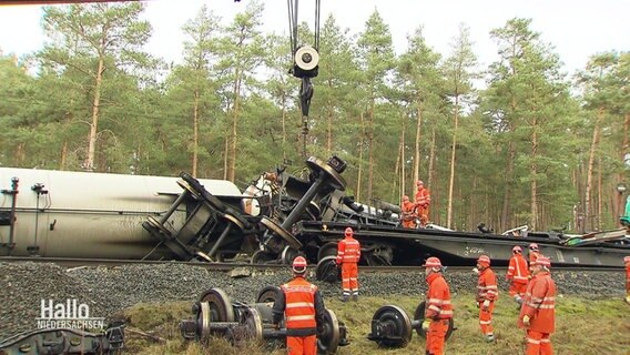 Mit einem Kran bergen Rettungskräfte Teile eines zerstörten Zuges. © Screenshot 