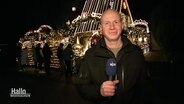 NDR Reporter Sven Borchart steht vor einem hell erleuchteten und weihnachtlich geschmücktem Haus. © Screenshot 