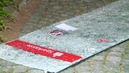 Die zersplitterte Glasscheibe einer Sparkassenfiliale liegt auf dem Boden. © Screenshot 