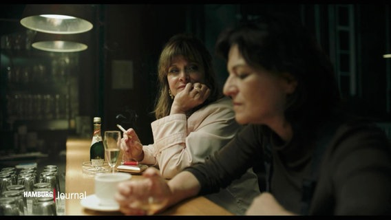 Zwei Frauen sitzen in einer Bar und rauchen. © Screenshot 