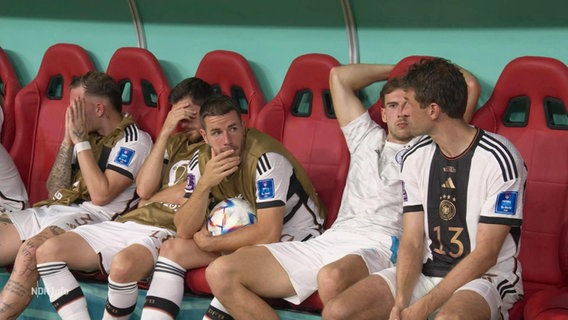Mehrere Nationalspieler Deutschlands sitzen frustriert auf einer Auswechselbank. © Screenshot 