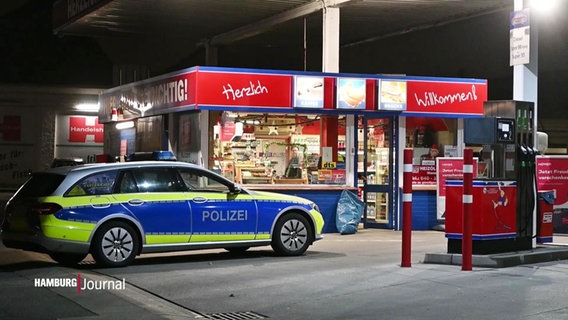 Ein Polizeiauto steht vor einer Tankstelle. © Screenshot 