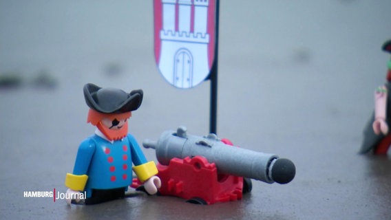 Eine Piraten-Spielfigur vor einem Hamburg-Wappen. © Screenshot 