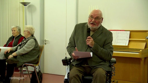 Ein Mann im Rollstuhl hält einen Vortrag. © Screenshot 
