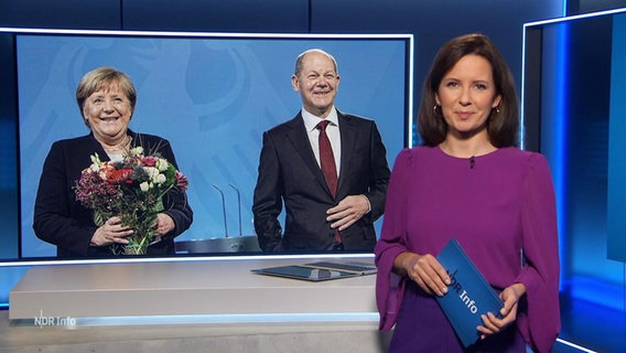 NDR-Moderatorin Romy Hiller vor einem Bild mit Angela Merkel und Olaf Scholz. © Screenshot 