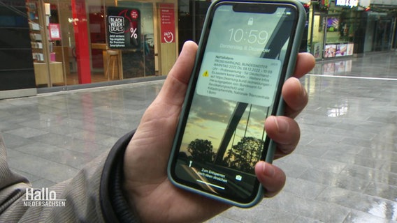 Ein Mann hält ein Smartphone in der Hand. © Screenshot 