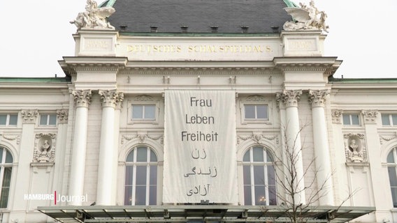 Das Schauspielhaus Hamburg mit einem Banner, auf dem steht: Frau Leben Freiheit. Darunter derselbe Text nochmals in arabischer Schrift. © Screenshot 