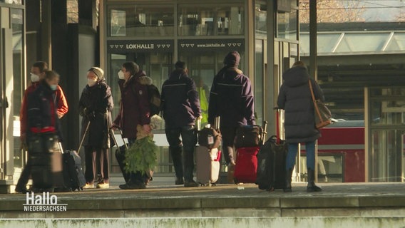 Ein Bahngleis auf dem mehrere Leute mit Taschen und Koffern stehen. © Screenshot 