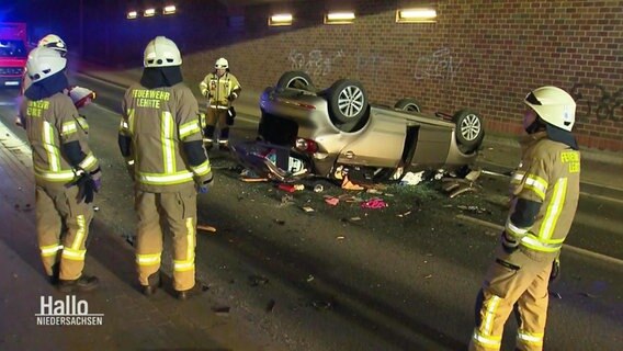 Mehrere Rettungskräfte stehen um ein Unfallauto. © Screenshot 