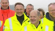 Bundesfinanzminister Lindner, Kanzler Scholz und Niedersachsens Ministerpräsident Stephan Weil bei der Eröffnung des neuen LNG-Terminals in Wilhelmshaven. © Screenshot 