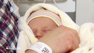 Ein Neugeborenes ist in eine Decke eingewickelt © Screenshot 