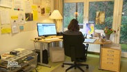 Eine Mitarbeiterin der Telefonseelsorge sitzt an ihrem Schreibtisch. © Screenshot 