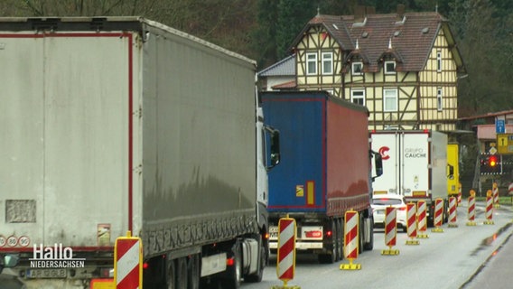 Lastkraftwagen stauen sich vor einer Ortschaft. © Screenshot 