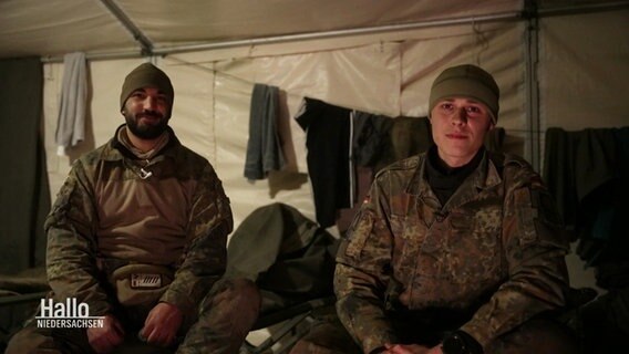 Zwei Bundeswehr-Soldaten sitzen auf Feldbetten nebeneinander in einem Schlafzelt. © Screenshot 