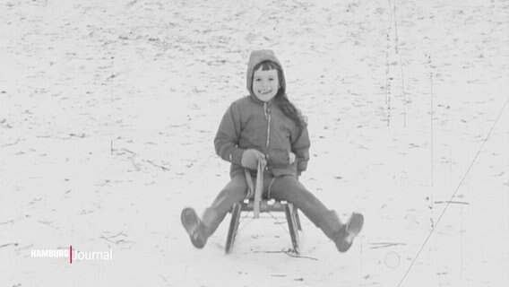 Ein rodelndes Kind auf einem schwarz-weiß Foto. © Screenshot 