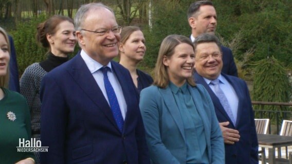 Die Kabinettsmitglieder der rot-grünen Regierung Niedersachsens sind bei einem Gruppenfoto in ausgelassener Stimmung. © Screenshot 