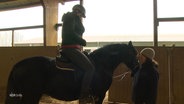 Eine Frau sitzt auf einem Pferd © Screenshot 