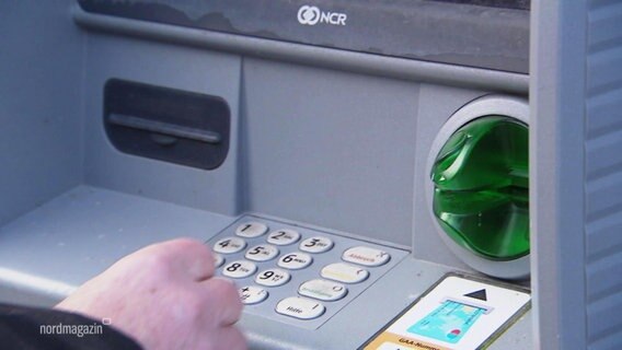 Eine Hand vor der Bedienungsfläche eines Geldautomaten © Screenshot 