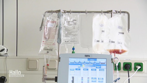 Beutel mit durchsichtiger Flüssigkeit oder mit Blut gefühlt, hängen über einem medizinischen Gerät. © Screenshot 
